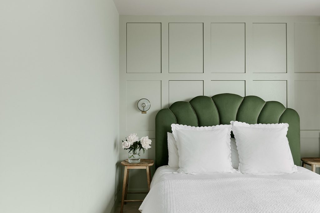 A bed with a green bedhead and a bedside table - Pakistan